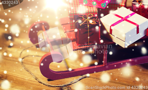 Image of close up of christmas gift boxes on wooden sleigh