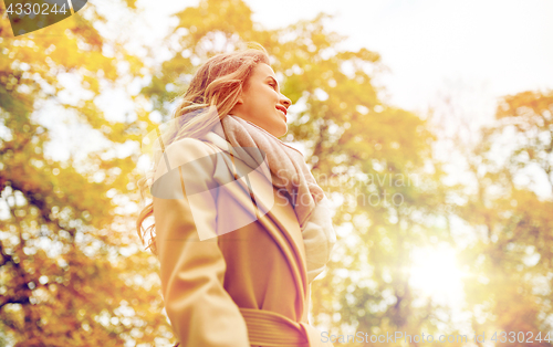 Image of beautiful happy young woman smiling in autumn park
