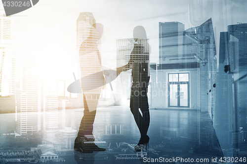 Image of business people shaking hands over city background