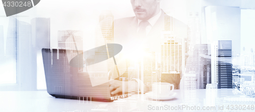 Image of businessman with laptop and coffee at office