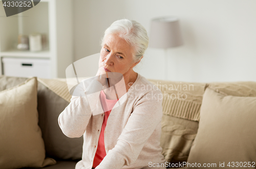 Image of senior woman suffering from neck pain at home