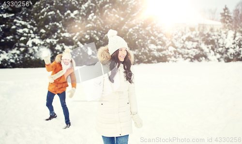 Image of happy couple playing snowballs in winter