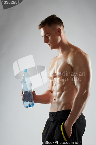 Image of young man or bodybuilder with bottle of water