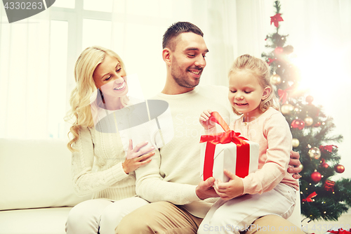 Image of happy family at home with christmas gift box