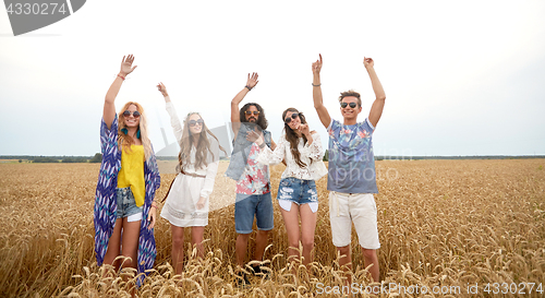 Image of happy young hippie friends dancing on cereal field