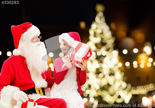 Image of santa claus and happy girl with christmas gift