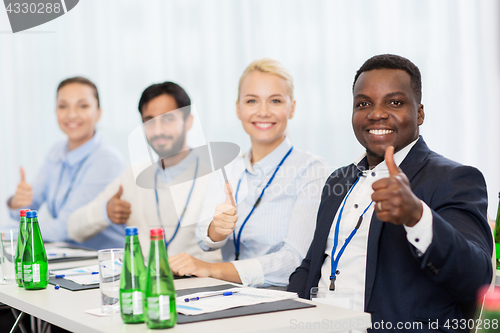 Image of people at business conference showing thumbs up