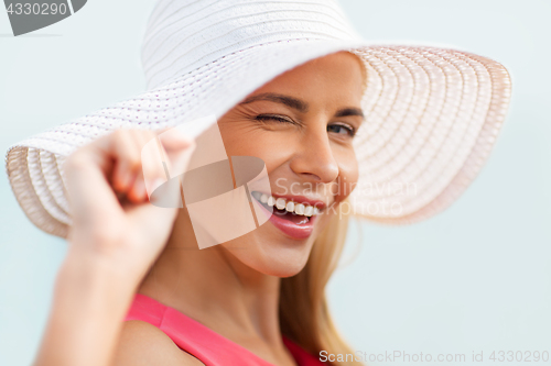 Image of portrait of beautiful smiling woman in sun hat