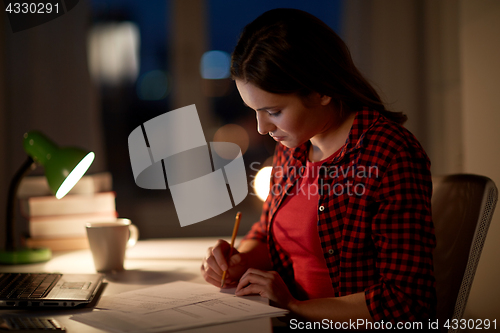 Image of student girl with laptop and notebook at home