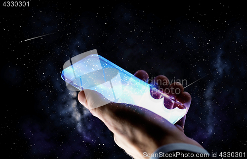 Image of close up of hand with glass smartphone over space