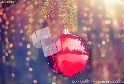 Image of red christmas ball on fir tree branch with snow