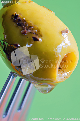 Image of Closeup grilled olive on the fork