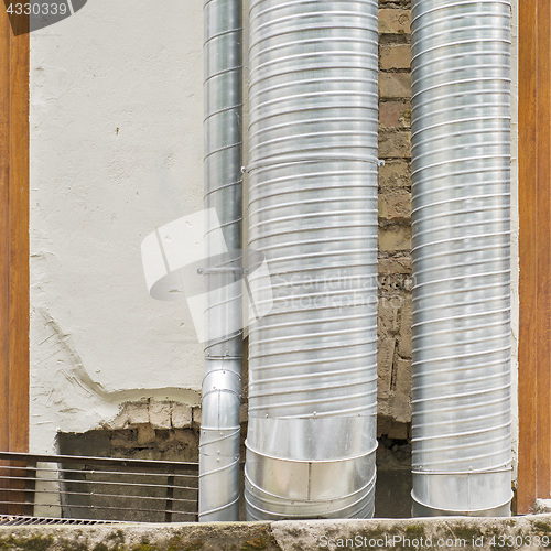 Image of air condition metal pipes near the wall
