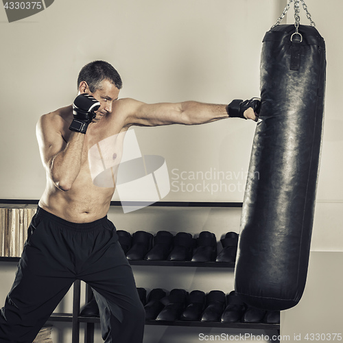 Image of a middle age man at the punch bag