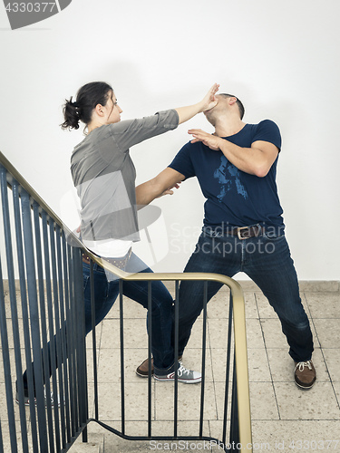 Image of young woman fighting with man