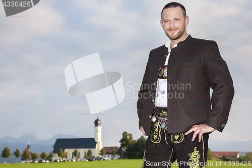 Image of bavarian tradition man with a church in the background