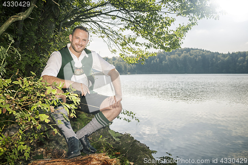 Image of bavarian tradition man at the lake