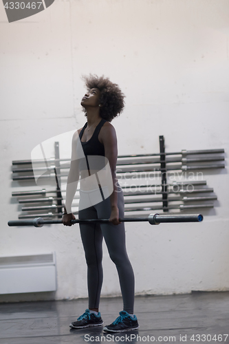 Image of black woman lifting empty bar