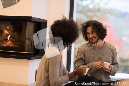 Image of multiethnic couple  in front of fireplace