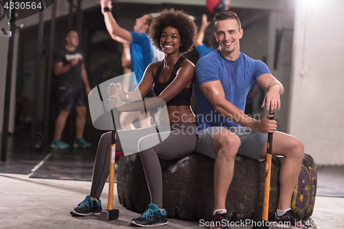 Image of multiethnic couple after workout with hammer