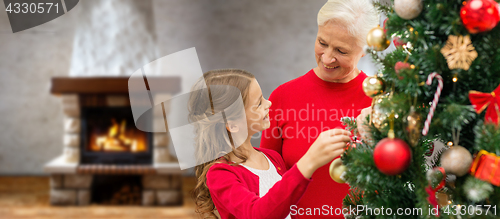 Image of grandmother and granddaughter at christmas tree