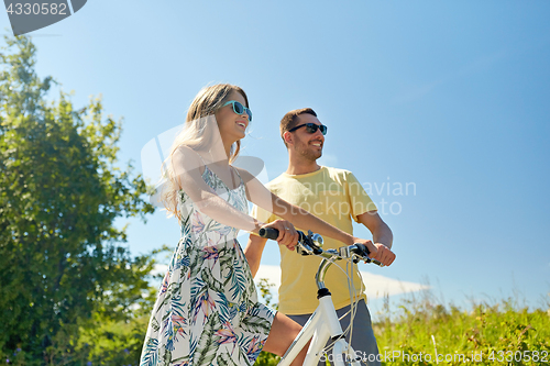 Image of happy couple with bicycle at country