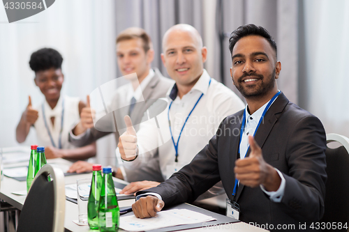 Image of people at business conference showing thumbs up