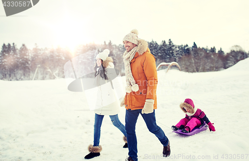 Image of happy family with sled walking in winter outdoors