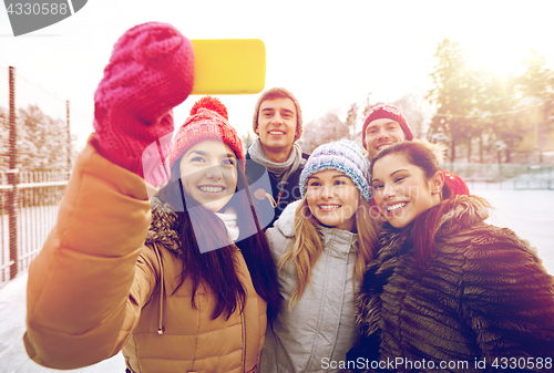Image of happy friends taking selfie with smartphone