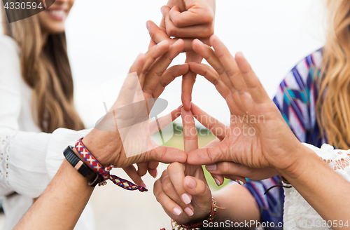 Image of hands of hippie friends showing peace sign