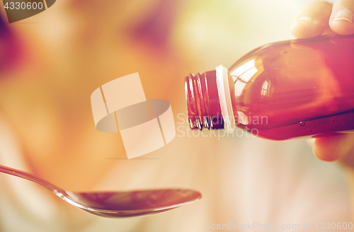 Image of woman pouring medication from bottle to spoon