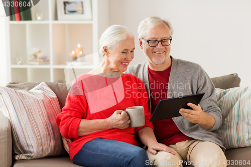 Image of happy senior couple with tablet pc at christmas