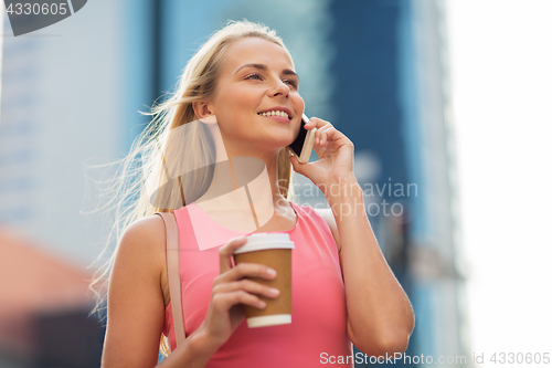 Image of woman with coffee calling on smartphone in city