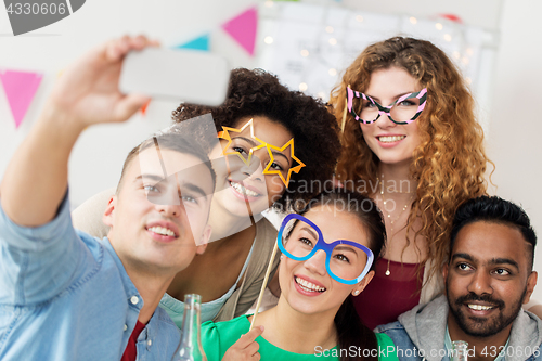 Image of happy team taking selfie at office party