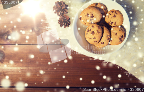 Image of close up of cookies in bowl and cones on fur rug