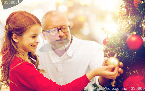 Image of grandfather and granddaughter at christmas tree