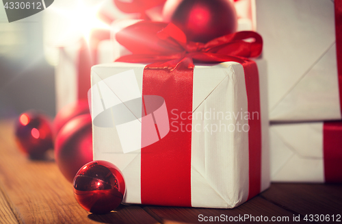 Image of close up of gift boxes and red christmas balls