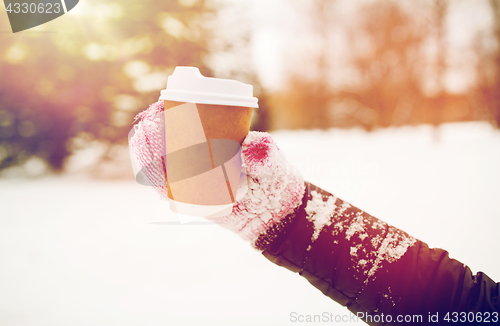 Image of close up of hand with coffee outdoors in winter