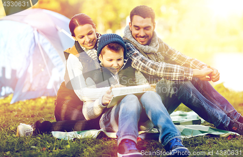 Image of happy family with tablet pc and tent at camp site