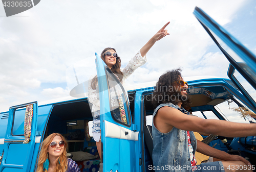 Image of smiling happy young hippie friends at minivan car