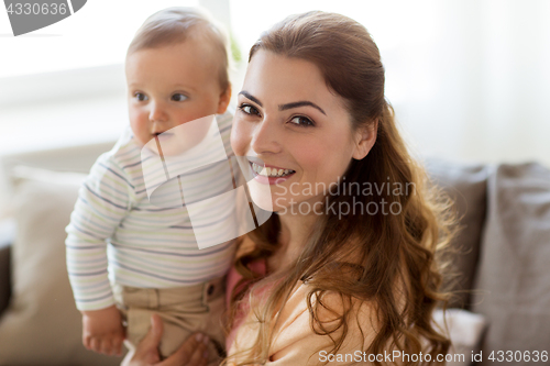 Image of happy young mother with little baby at home