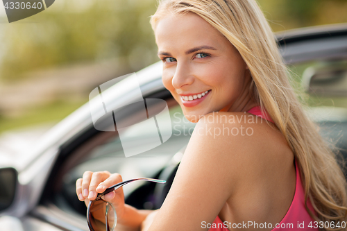 Image of happy young woman in convertible car