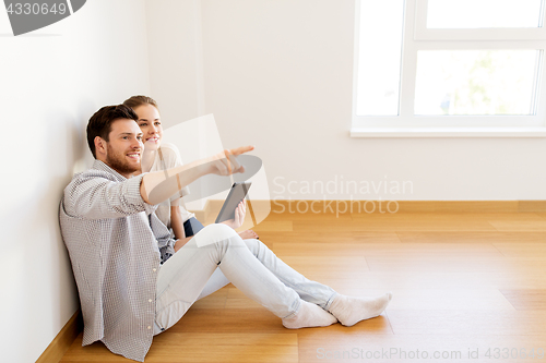 Image of happy couple with tablet pc computer at new home