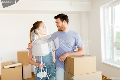 Image of couple with boxes and lamp moving to new home