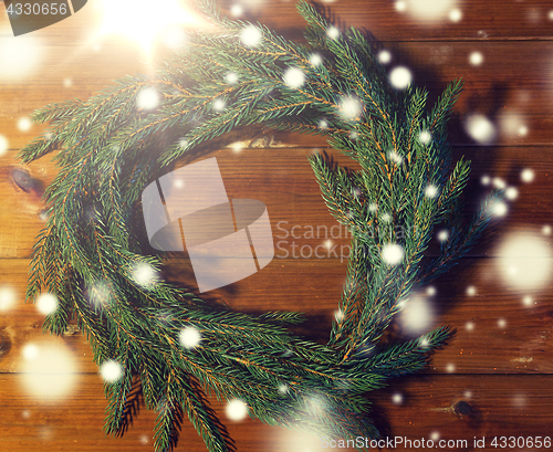 Image of natural green fir branch wreath on wooden board