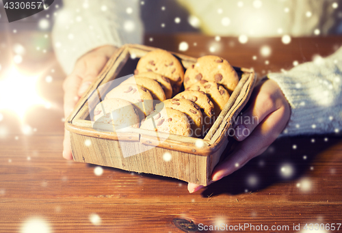 Image of close up of woman with oat cookies at home