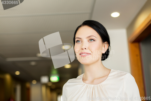 Image of happy woman at corridor in hotel