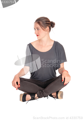 Image of Woman sitting with closed legs on floor.