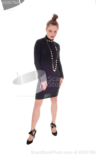 Image of Woman in black dress standing.