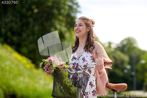 Image of happy woman riding fixie bicycle in summer park